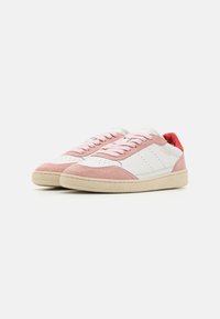 Rosa semsket og hvite skinn sneakers med gummisåle, med rosa lisser og en rød interiørakent. Perforerte detaljer på siden.