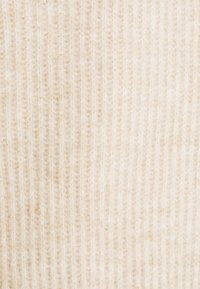 Béžová žebrovaná látka s jemnou texturou, která ukazuje jemné vertikální pruhy a subtilní lesk. Vhodná pro oděvy nebo doplňky.