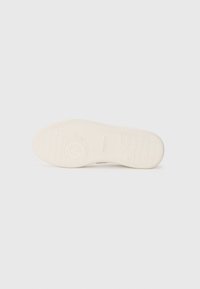 Semelle de sneaker en caoutchouc blanc, avec un motif de semelle texturé et un accent de logo circulaire. Fini lisse sans marques ou détails visibles.