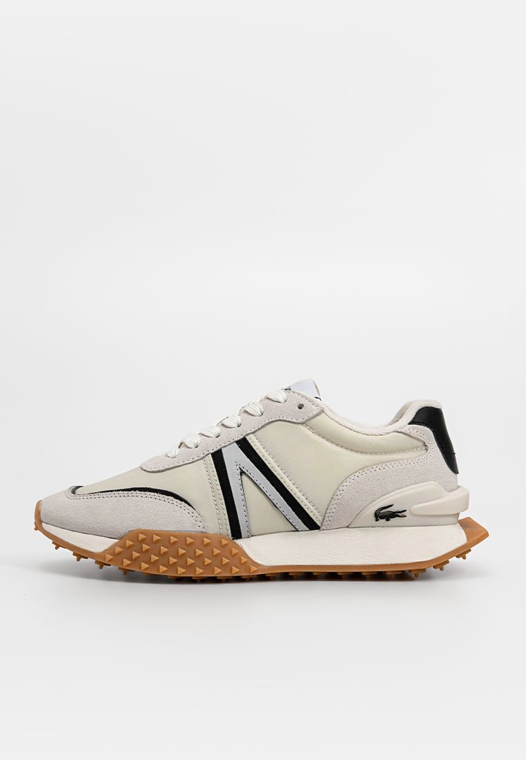 Zapatillas con parte superior de ante y cuero en beige, acentos en negro y gris, suela de goma con picos y un logo en el talón.