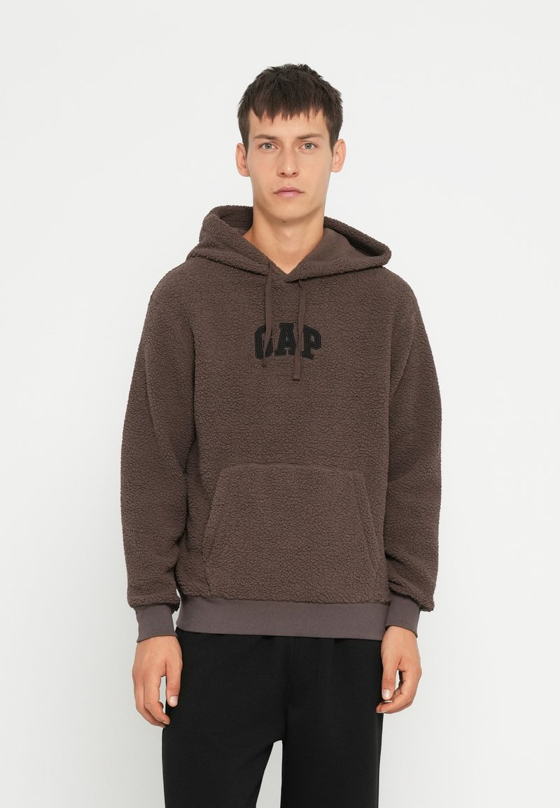 Smešani smeđi dukserica s kapuljačom, s kenguruvim džepom i crnim "GAP" logotipom. Mekan tekstur, podesiva kapuljača s rastezljivim manžetama.