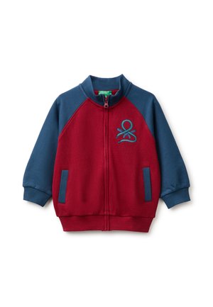 Chaqueta infantil con cremallera, mangas y cuello azules, cuerpo rojo, bolsillos laterales y logo azul bordado en el pecho izquierdo.
