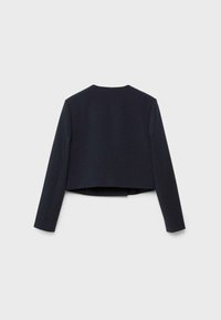 Blazer noir court à manches longues, vu de dos sur un fond gris clair uni.