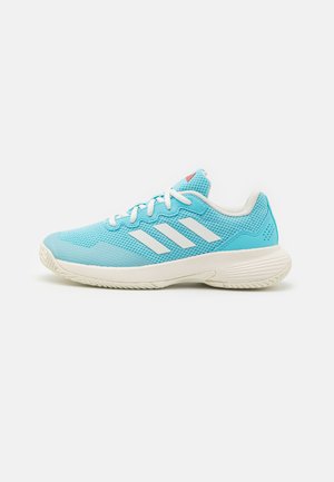 Zapatilla deportiva azul clara con parte superior de malla, acentos blancos y tres rayas blancas. Cuenta con una suela acolchada y una suela exterior de goma texturizada.