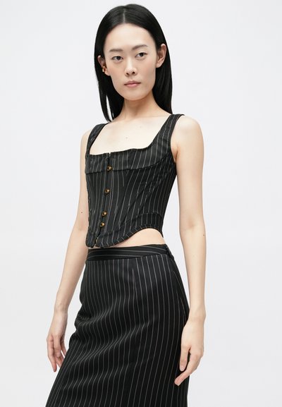 Top de corsé negro a rayas con cuello cuadrado, con acentos de botones dorados y una silueta ajustada, combinado con una falda larga a juego.