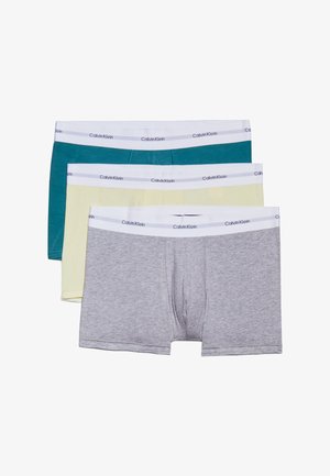 Tri páry boxeriek: tyrkysové, žlté a šedé. Každé má biely pás s nápisom "Calvin Klein". Mäkký materiál z bavlneného zmesi.