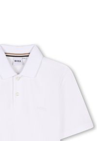 Polo bianco realizzato in tessuto testurizzato, dotato di colletto classico, chiusura a tre bottoni e logo ricamato in modo discreto sul petto.