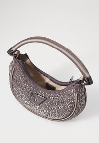 Paarse handtas met sprankelende rhinestones, ronde vorm, een ritssluiting en een slanke handgreep. Heeft een subtiel logo aan de zijkant.