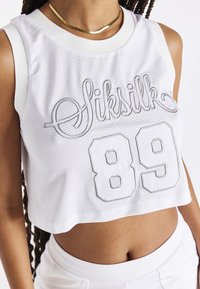 Weißes ärmelloses Crop-Top mit Mesh-Textur, das auf der Vorderseite mit silberner Stickerei "Siksilk" und der Nummer "89" verziert ist, runder Halsausschnitt.