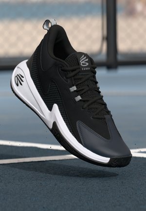 Scarpa sportiva nera con pannelli in rete, design aerodinamico, suola bianca e dettagli grigi. Presenta una linguetta per il pull e il logo del marchio sulla linguetta.