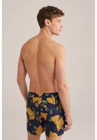 Herren-Bade shorts aus leichtem Stoff, mit einem navyfarbenen Hintergrund und einem Muster aus gelben Früchten und Blättern. Sie besitzen einen elastischen Bund und eine Gesäßtasche.