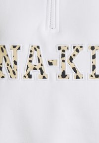 Sweat-shirt blanc avec un col zippé. L'avant présente "NA-KD" en tissu beige avec un motif léopard noir.
