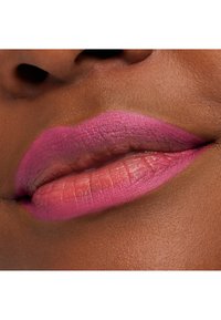 Rouge à lèvres rose appliqué sur des lèvres pulpeuses, avec un dégradé allant d'un rose plus intense à une teinte plus claire, sur un fond de peau lisse et foncée.