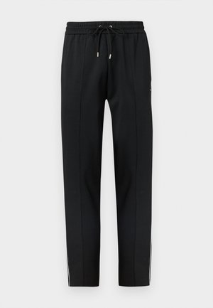 Black tapered sweatpants with elastic waistband and drawstring, featuring subtle seam details and white side stripes on the lower legs.