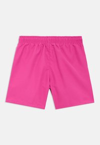 Bañador corto rosa con una tela lisa y ligera, cintura elástica y sin bolsillos ni adornos visibles.