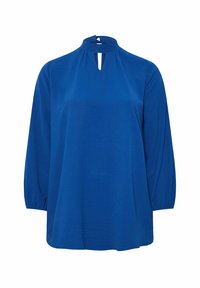 Blusa blu a maniche lunghe con collo alto, apertura a chiave davanti e vestibilità rilassata. Il tessuto sembra morbido con una leggera trama.