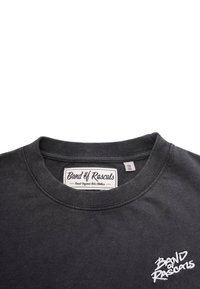 Tummanharmaa lyhythihainen t-paita, jossa on pyöreä kaula-aukko, valkoisella brodeeratulla logolla ja tarratunnuksella varustettuna. Valmistettu pehmeästä puuvillamateriaalista.