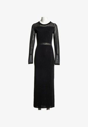 Longue robe noire avec manches longues en maille transparente, empiècement en maille et détail de ceinture en maille sur un mannequin blanc.