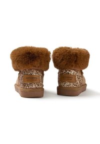 Botas de tobillo marrones con puños de piel esponjosa, que presentan un patrón brillante en dorado y beige, y un parche con el logo en la parte trasera. Textura suave.