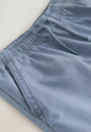 Hele sinised lühikesed püksid, valmistatud pehmest kangast, millel on elastne vöökoht nööriga ja küljetaskud. Sile pind, vabaaja disain.