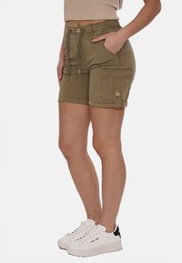 Pantaloni cargo verde oliva realizzati in misto cotone, dotati di quattro tasche, vita con cordino e dettagli in metallo dorato.