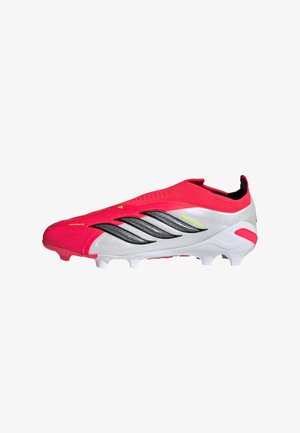 Roter und weißer Adidas Predator Fußballschuh mit schwarzen Streifen und geformten Stollen, entwickelt für Spiele auf festem Boden.