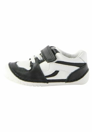 Czarno-białe sneakersy z rzepem, gumową podeszwą i skórzaną cholewką; zakrzywiony kształt z detalami przeszycia i akcentującymi liniami.