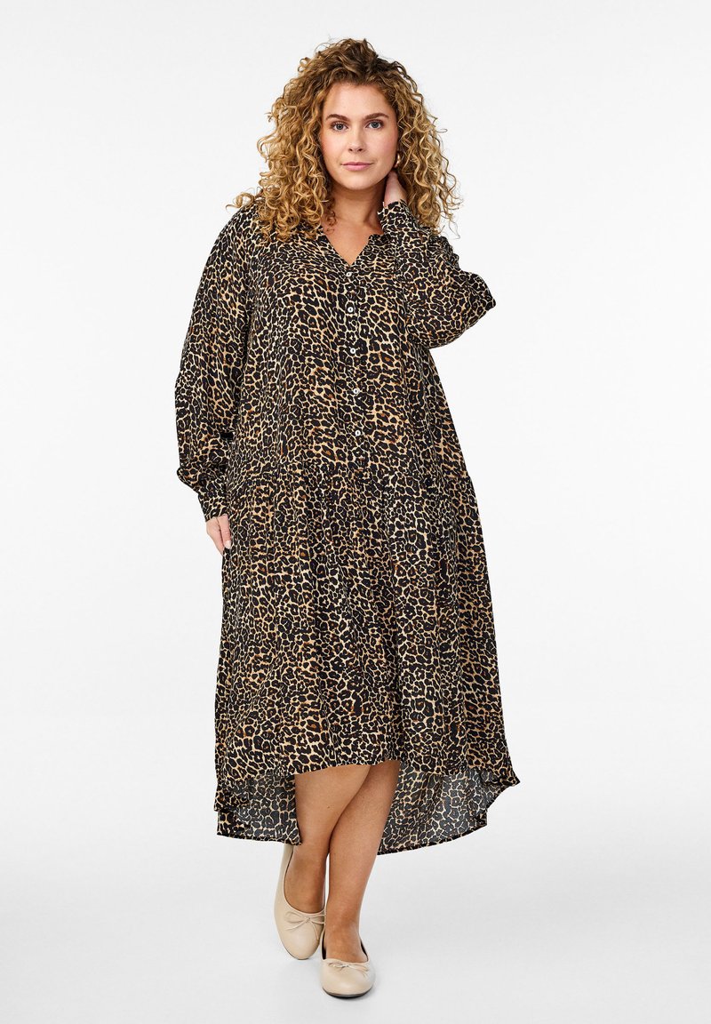 Leoprint-Kleid aus leichtem Stoff, mit durchgehender Knopfleiste, langen Ärmeln und asymmetrischem Saum. Neutrale Ballerinas runden den Look ab.