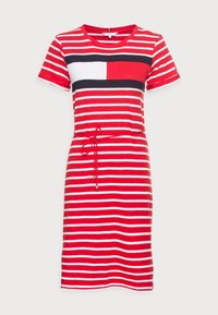 Punainen ja valkoinen raidallinen mekko, jossa tummansiniset lohkot muotoilevat rintaa, lyhyet hihat ja sidottu vyötärö, joka antaa hyvin istuvan muodon. Pehmeä kankaan rakenne.