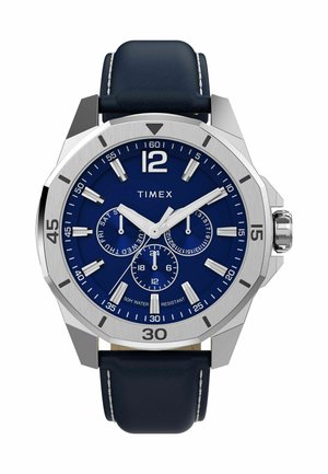 Montre Timex avec un cadran bleu, un boîtier en acier inoxydable argenté et un bracelet en cuir bleu marine. Caractéristiques : grands repères horaires et sous-cadrans de chronographe.