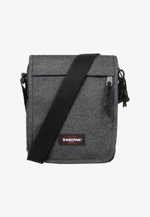 Grå stof crossbody taske med klaplukning, justerbar sort strop, logo-patch på forsiden og dekorativ lynlås-trækdetalje.