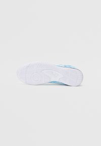 Suela de zapato con una base de goma blanca, texturizada con patrones en zigzag y circulares, que presenta un diseño superior de malla en azul y blanco.