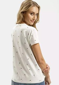 Biała koszulka z krótkim rękawem w kwiatowy wzór, z okrągłym dekoltem i luźnym krojem. Miękki, gładki materiał o subtelnej teksturze.