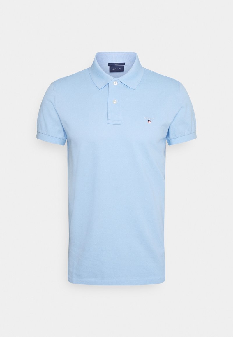 Polo bleu clair ajusté à manches courtes, patte de boutonnage à deux boutons et petit logo brodé sur le côté gauche de la poitrine.