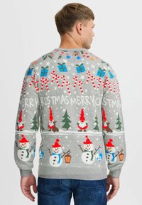 Grau gestrickter Pullover mit festlichen Mustern von Schneemännern, Weihnachtsbäumen, Geschenkboxen, Zuckerstangen und dem Text "FROHE WEIHNACHTEN" in bunten Akzenten.