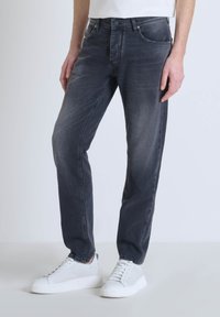Jean en denim gris foncé avec une coupe droite, comportant cinq poches, une fermeture à bouton et un léger délavage sur les cuisses.