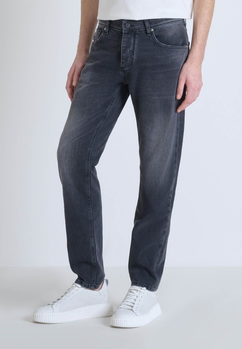 Jean en denim gris foncé avec une coupe droite, comportant cinq poches, une fermeture à bouton et un léger délavage sur les cuisses.