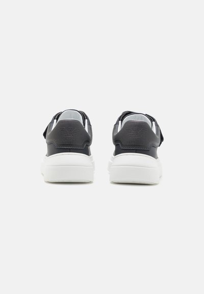 Mörkblå sneakers med vita sulor, med en texturerad bakpanel och minimalistisk design. Ingen synlig logotyp eller mönster.