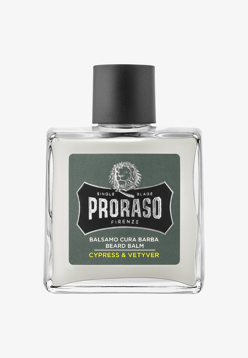 Bottiglia di vetro trasparente con un tappo nero, etichettata "Proraso Beard Balm." Sfondo verde sull'etichetta, con un logo di leone e dettagli del prodotto in bianco e giallo.