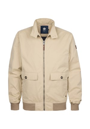 Jachetă bomber bej cu fermoar frontal, două buzunare mari în față și manșete și tiv cu nervuri. Are accente subtile de culoare maro și un guler clasic.