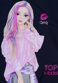 Illustrazione di una giovane donna con capelli lunghi caratterizzati da ciocche rosa e viola. Indossa una maglietta rosa e tiene una borsa argentata. Il testo recita "Christy" e "TOP Model."