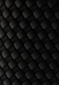 Tissu noir tissé présentant un motif en quadrillage avec des bandes entrelacées, créant une surface texturée adaptée aux sacs ou à la garniture.