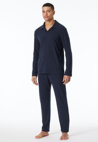 Navyblaues Langarm-Pyjama-Set mit einem kragenlosen Oberteil und passenden Hosen, gefertigt aus einem glatten Stoff, der für Komfort und Bewegungsfreiheit sorgt.