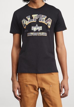 Sort bomuld T-shirt med korte ærmer, med farverig "ALPHA INDUSTRIES" tekst og logo trykt på fronten i camouflage stil.