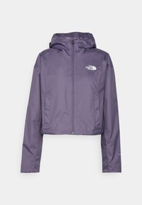Chaqueta impermeable morada con cremallera frontal, capucha ajustable y logo en el pecho izquierdo. Textura lisa; diseño corto.