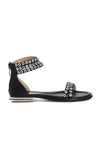 Musta sandaali, jossa on metalliset niittikoristeet, nilkkaremmi soljella, litteä pohja ja hopeanvärinen suorakulmainen korko. Teksturoitu nahkadesign.
