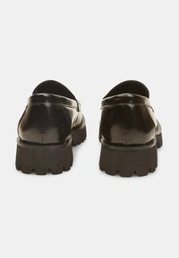 Scarpe in pelle laccata nera con suola in gomma spessa, caratterizzate da una punta tonda e un taglio basso per una facile calzata.