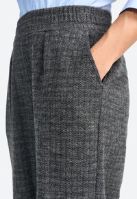 Pantalons gris en chevron avec un tissu texturé, dotés de poches latérales et d'une taille avec une finition élastique pour le confort.