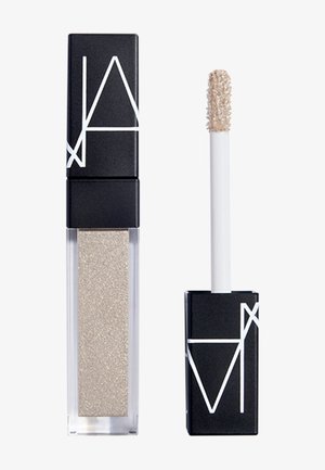 Contenant rectangulaire transparent pour gloss à lèvres avec un liquide beige brillant et un bouchon noir avec un motif géométrique blanc et un applicateur.