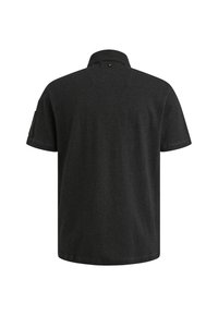 Zwarte polo met korte mouwen en een klassieke kraag. Officieel met een knoop aan de achterkant van de hals en een patch op de linker mouw.